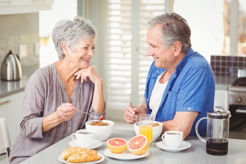 due anziani che mangiano e sorridono