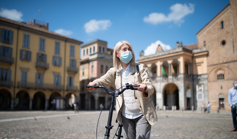 Donna con bici e mascherina in città