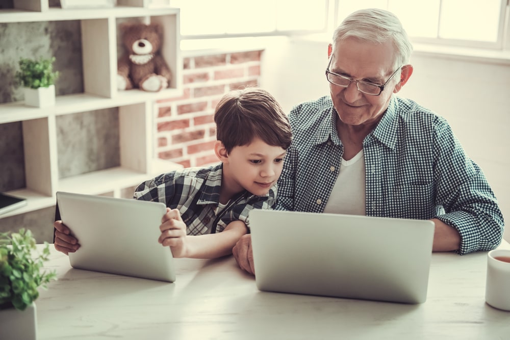 Un nonno e un nipote usano insieme i device