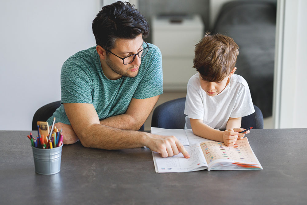 Un padre aiuta il figlio con i compiti