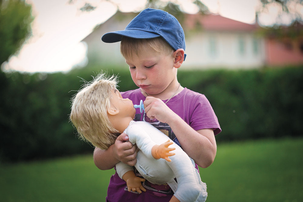 Un bambino gioca con una bambola