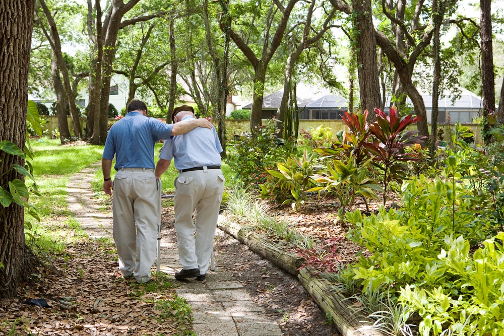 Un giovane e un anziano camminano al parco